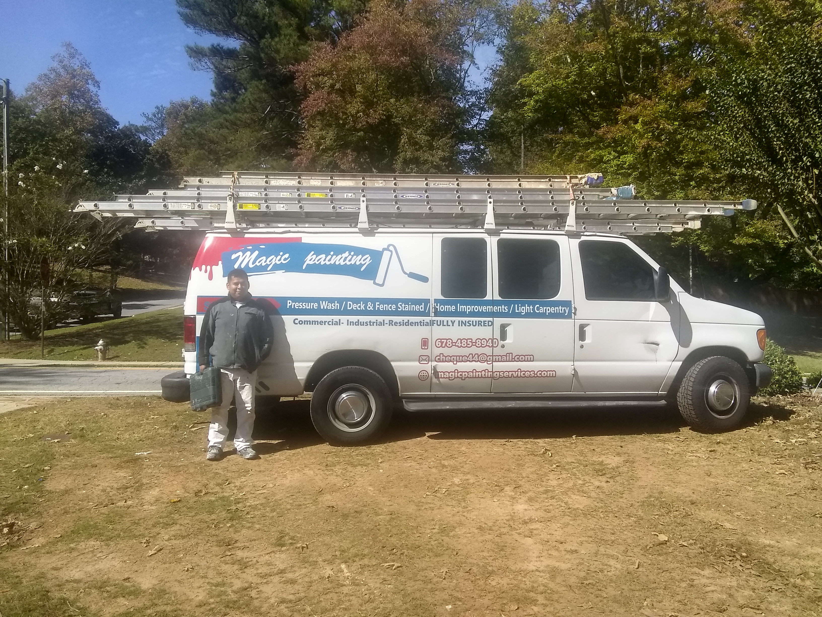 Roberto Fierro, owner of Magic Painting, standing next to the company van